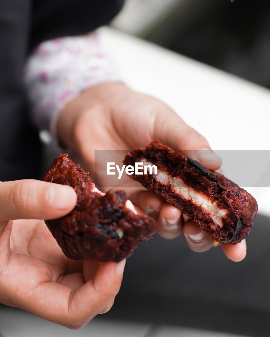 Close-up of hand holding red velvet cookie