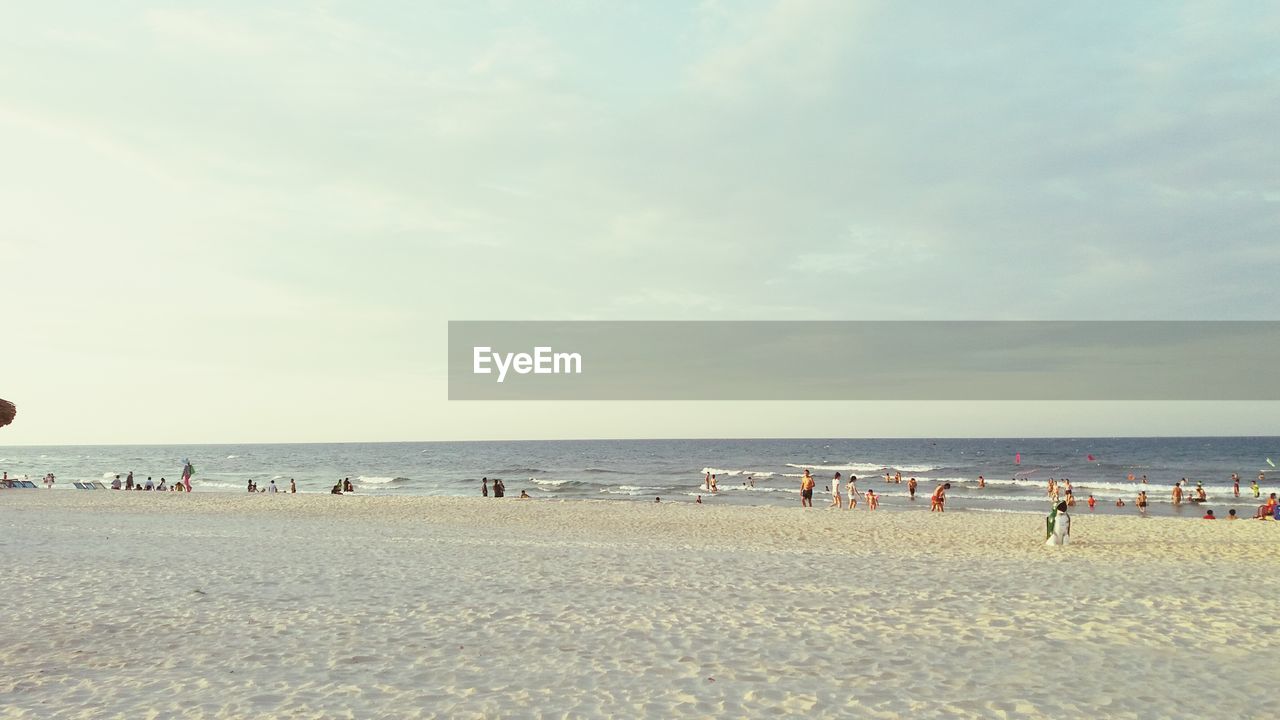 People on beach against sky