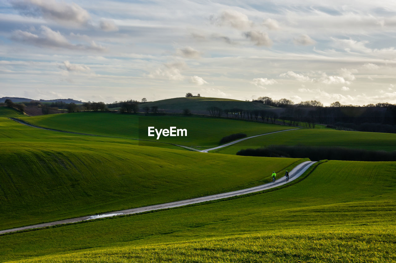 Road amidst field against sky