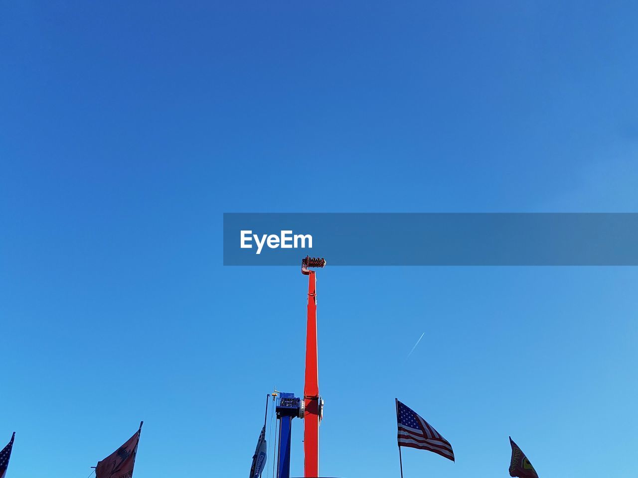 Low angle view of carousel  against clear blue sky