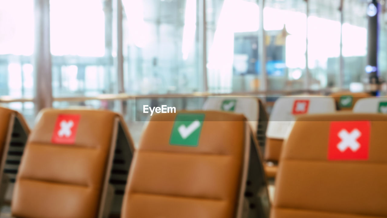 Social distancing, rows of empty chairs in an airport's departure area 