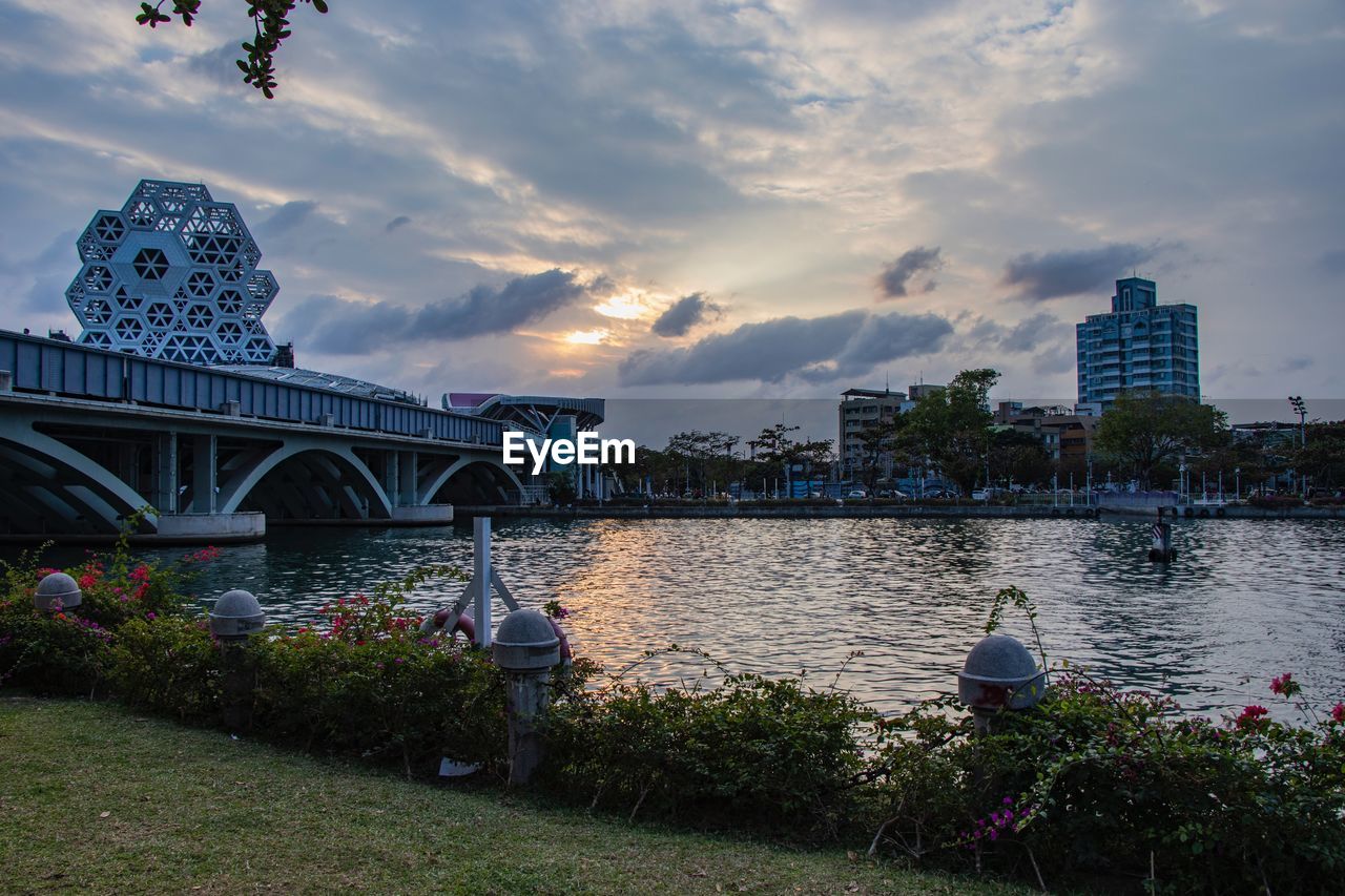 BRIDGE OVER RIVER AGAINST SKY IN CITY