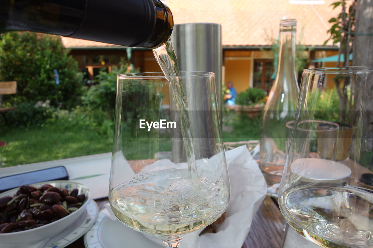 food and drink, glass, wine glass, meal, food, table, drink, wine, drinking glass, household equipment, restaurant, refreshment, brunch, container, bottle, alcohol, no people, nature, wine bottle, freshness, plant, day, outdoors, business, focus on foreground, healthy eating