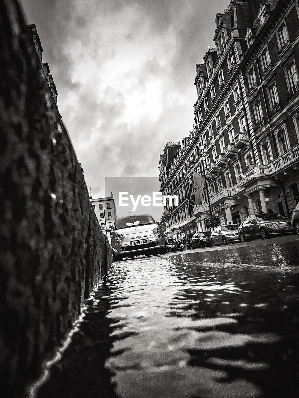 Cars by puddle on street during monsoon