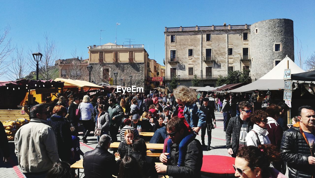 PEOPLE ON STREET BY BUILDINGS IN CITY