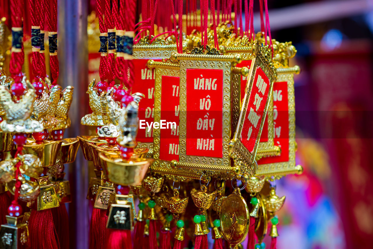 CLOSE-UP OF RED LANTERNS HANGING IN TRADITIONAL CLOTHING