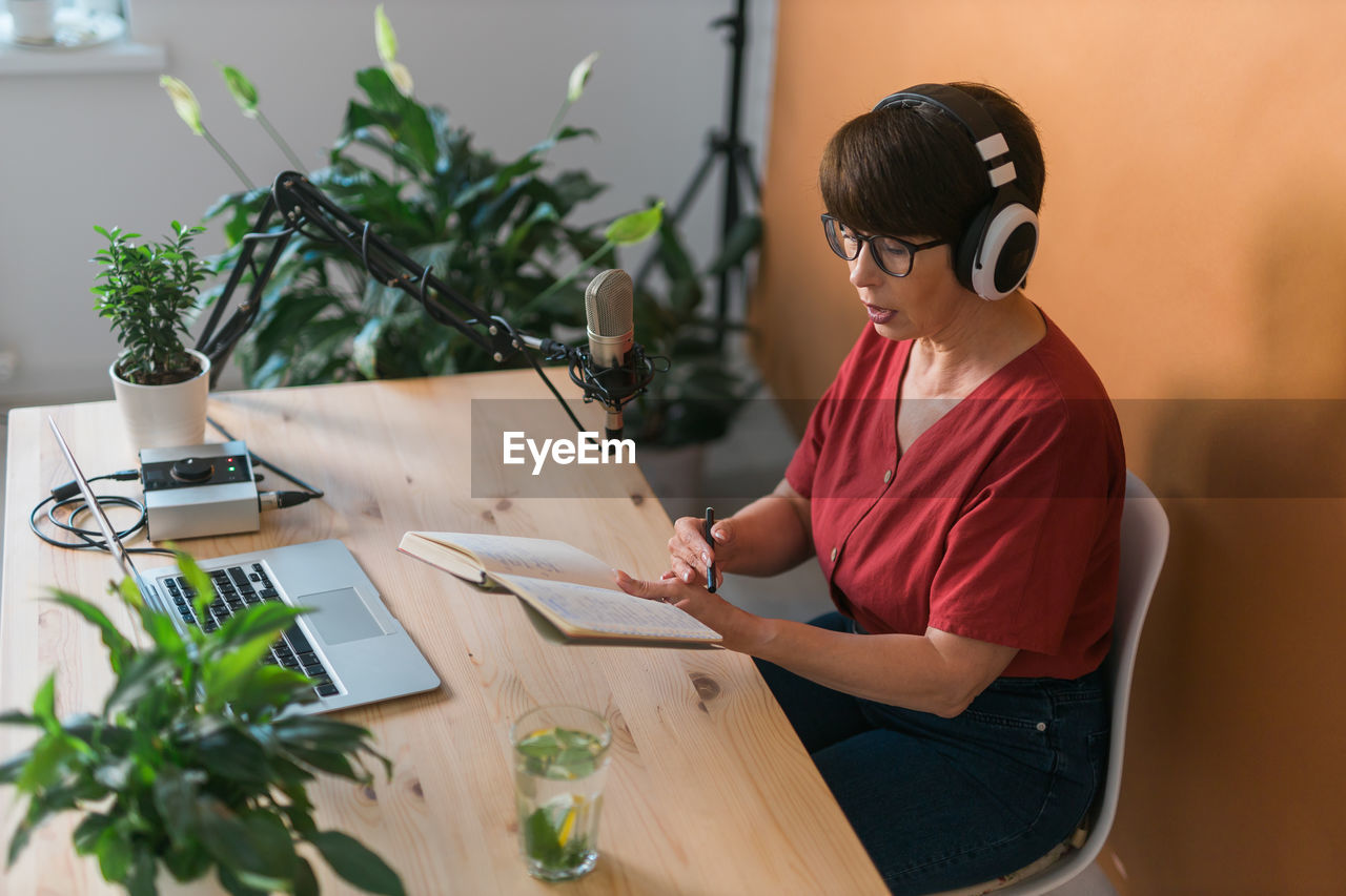 Senior woman with laptop sitting at table