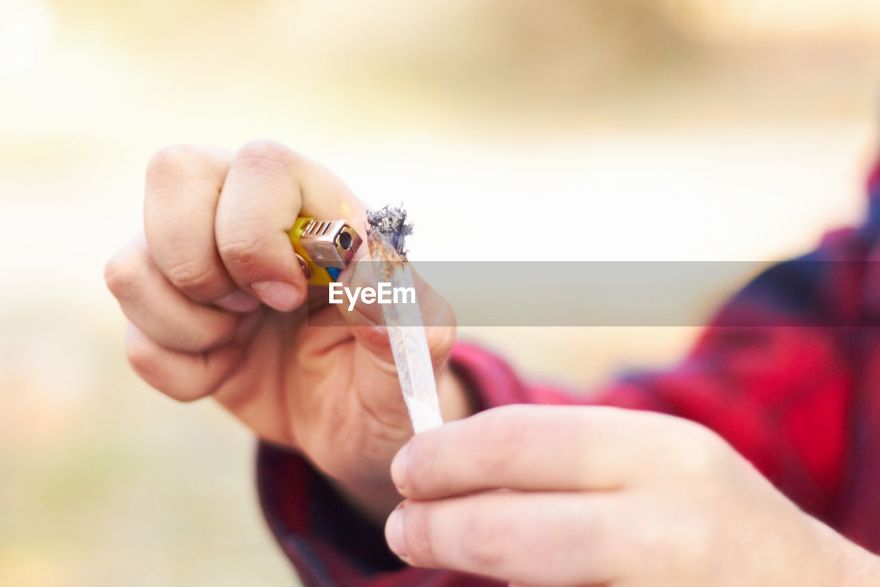 cropped hand of man holding thermometer