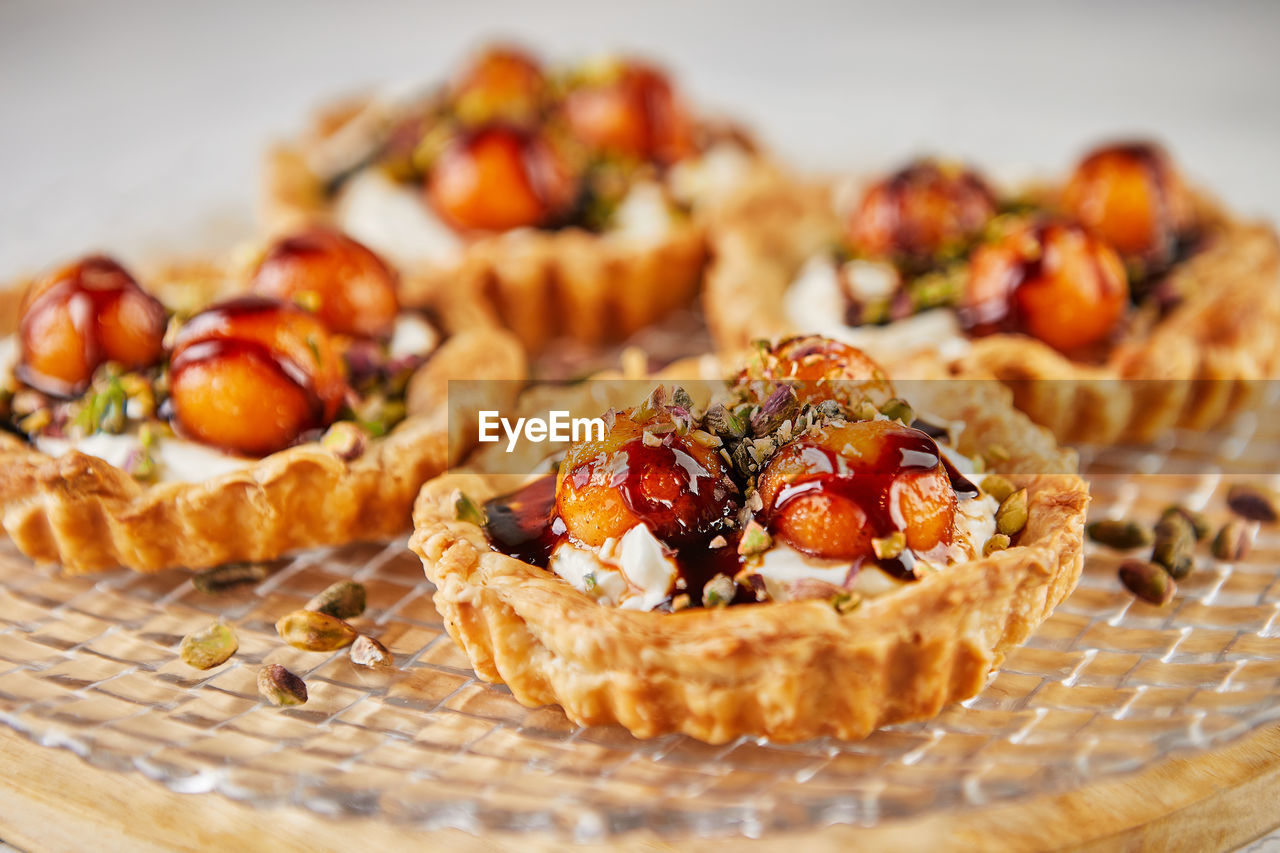 Tartlets with melon, mascarpone and pistachios on transparent plate