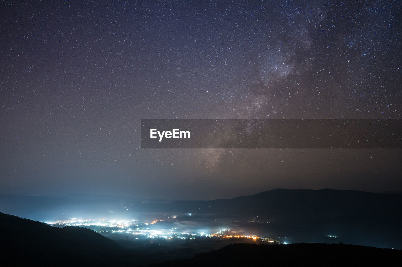 SCENIC VIEW OF MOUNTAINS AGAINST STAR FIELD