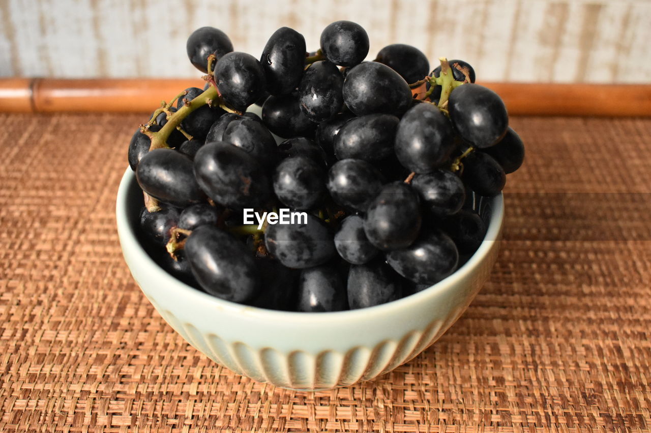 HIGH ANGLE VIEW OF GRAPES IN CONTAINER ON TABLE