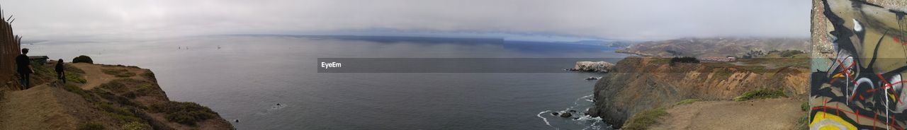 VIEW OF SEA WITH MOUNTAIN IN BACKGROUND