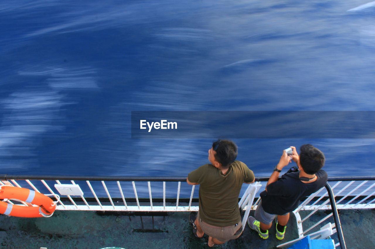 High angle view of men standing at railing