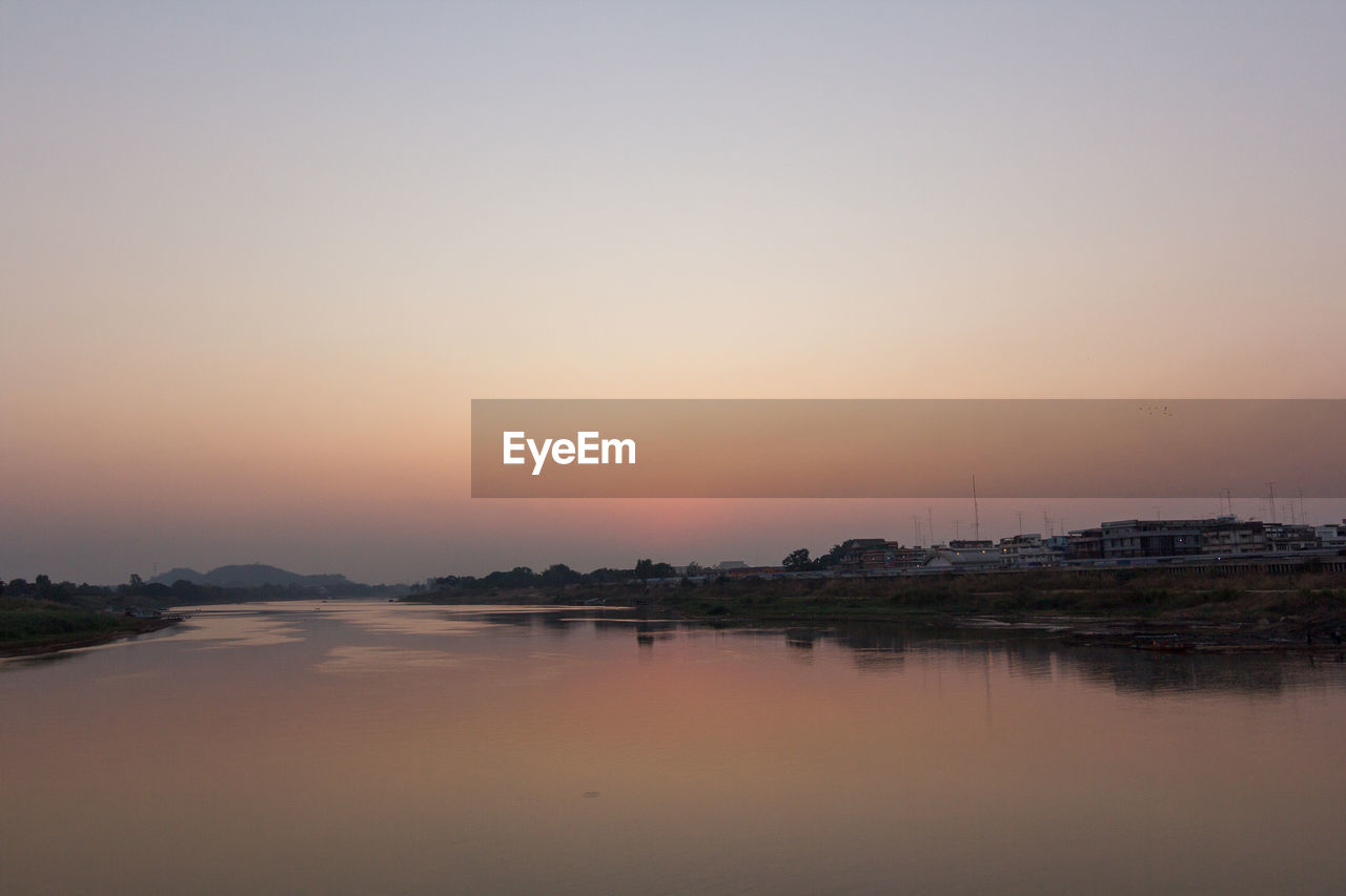 Scenic view of lake against clear sky during sunset