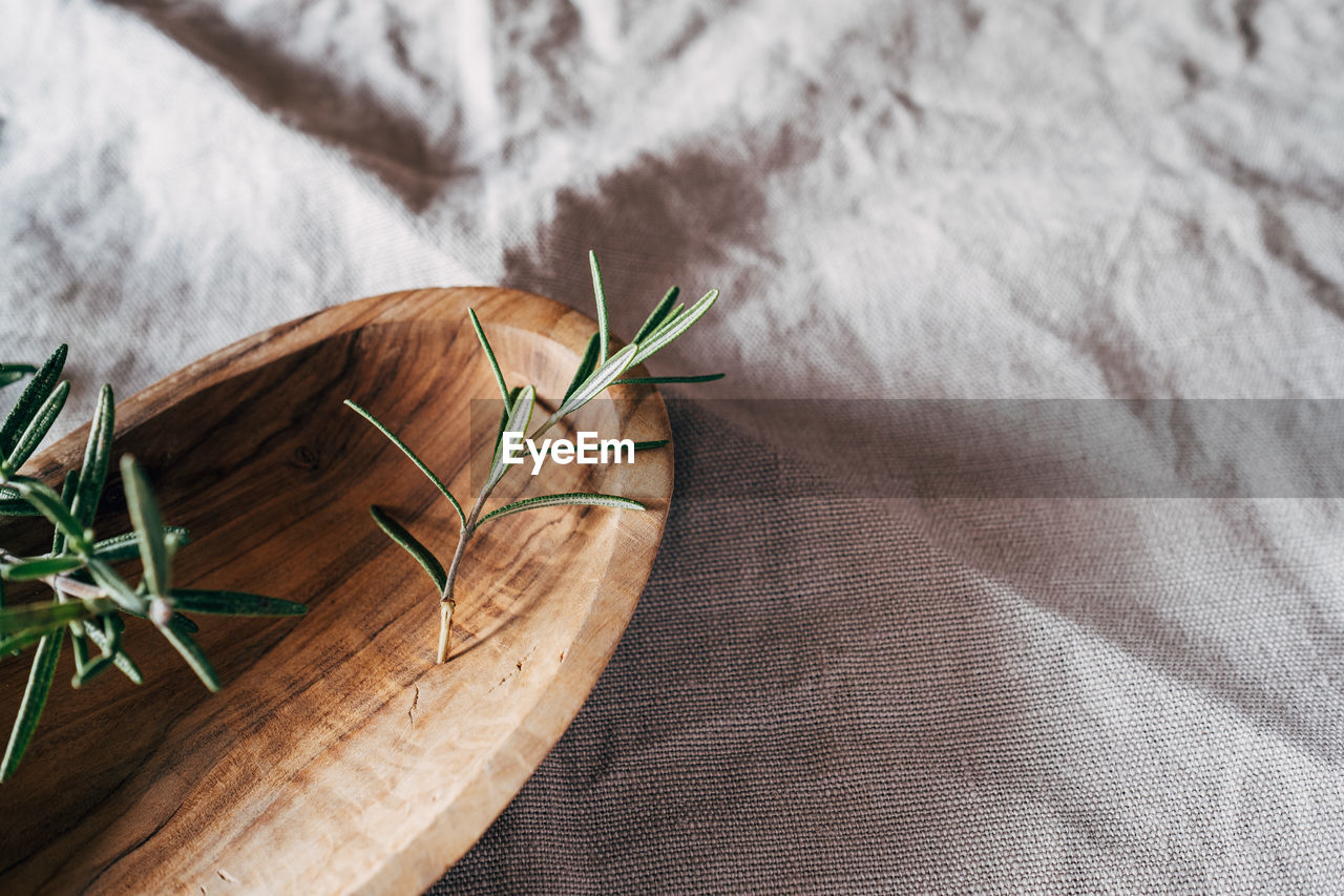 Rosemary in wooden bowl on towel