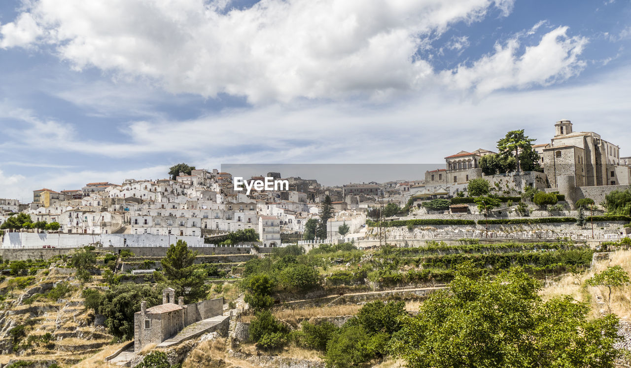 Buildings in town against cloudy sky