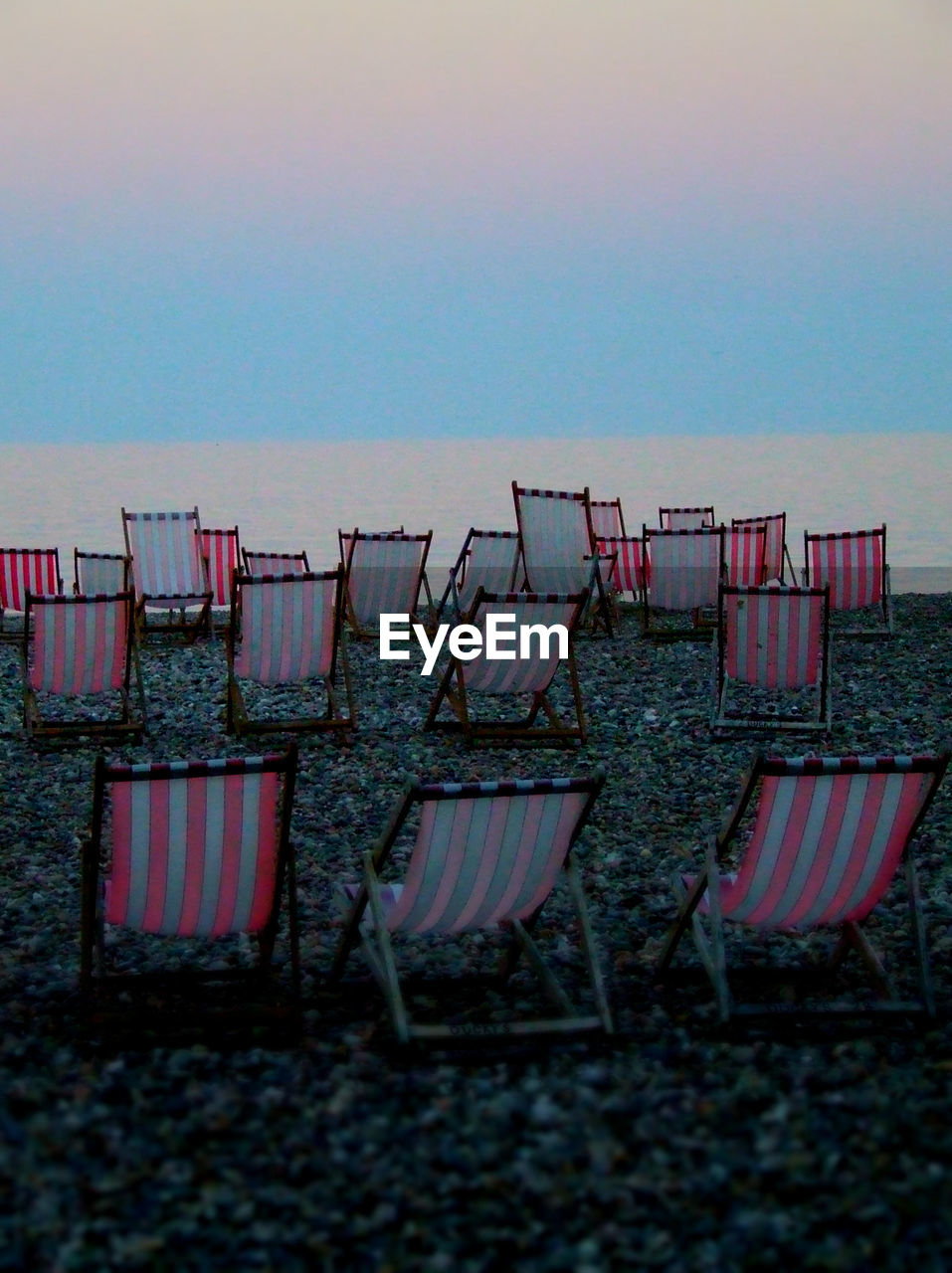 DECK CHAIRS AT BEACH AGAINST CLEAR SKY