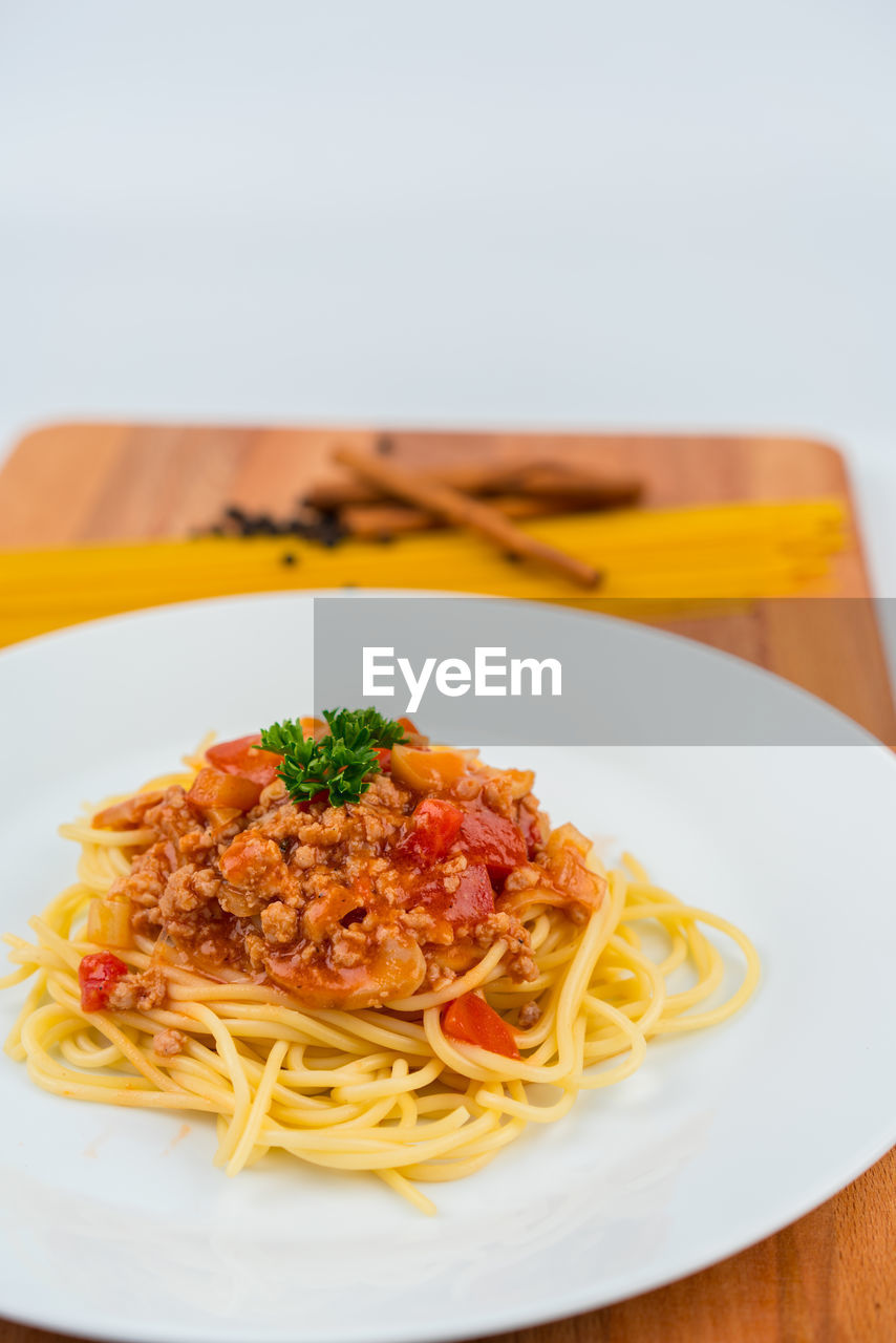 Close-up of spaghetti in plate on white background