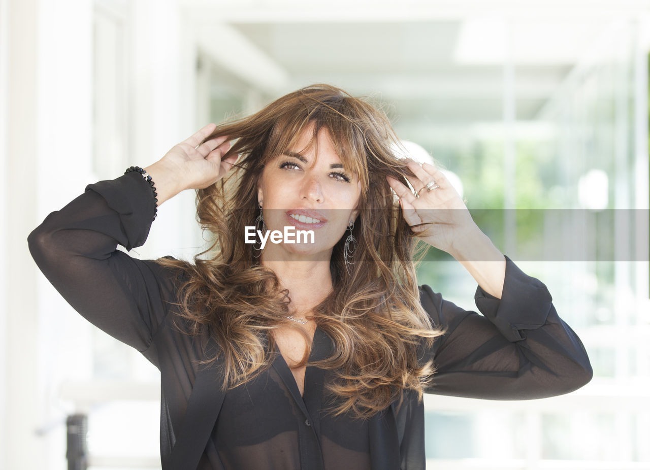 Portrait of smiling mature woman standing in balcony