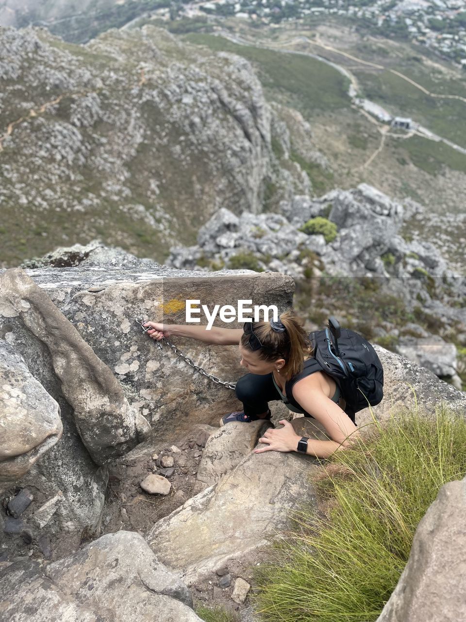 side view of man sitting on rock