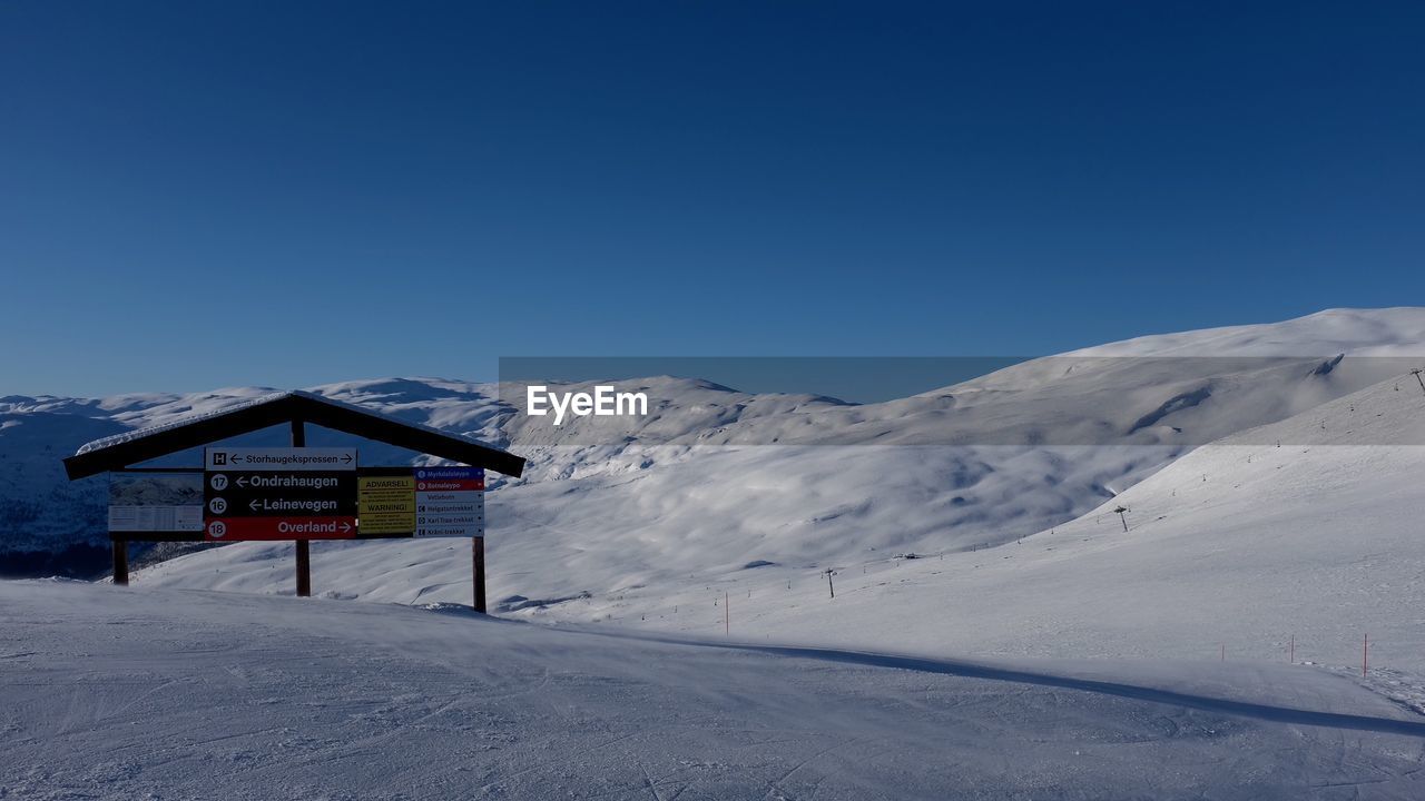 Scenic view of snow covered mountains against clear sky