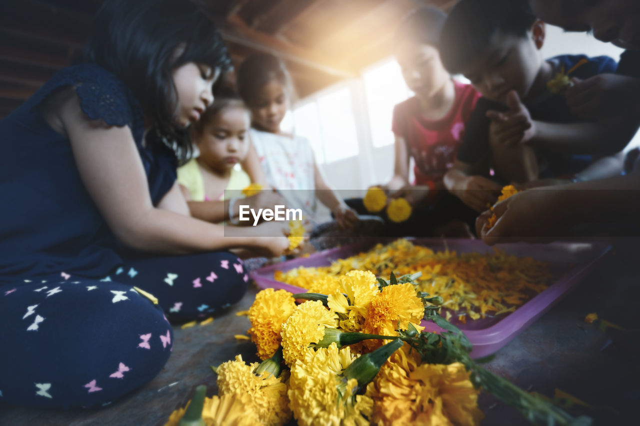 HIGH ANGLE VIEW OF CHILDREN HOLDING PEOPLE IN KITCHEN