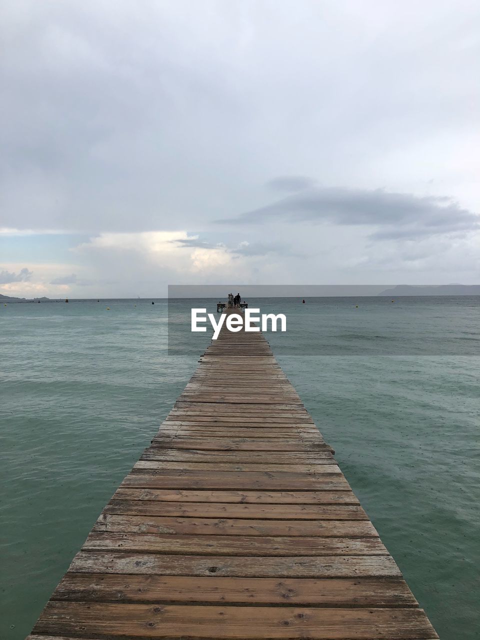 WOODEN PIER LEADING TO SEA AGAINST SKY