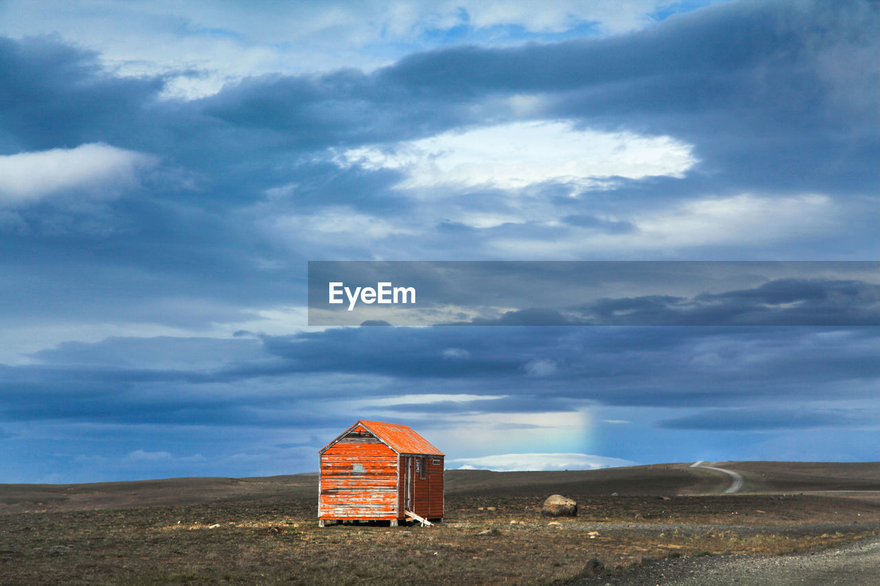 Abandoned hut against cloudy sky