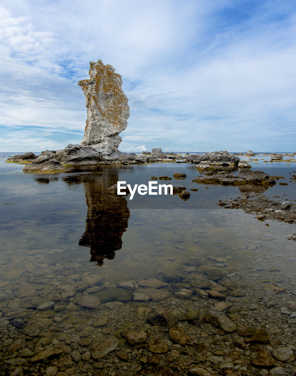 ROCK FORMATION ON SHORE AGAINST SKY