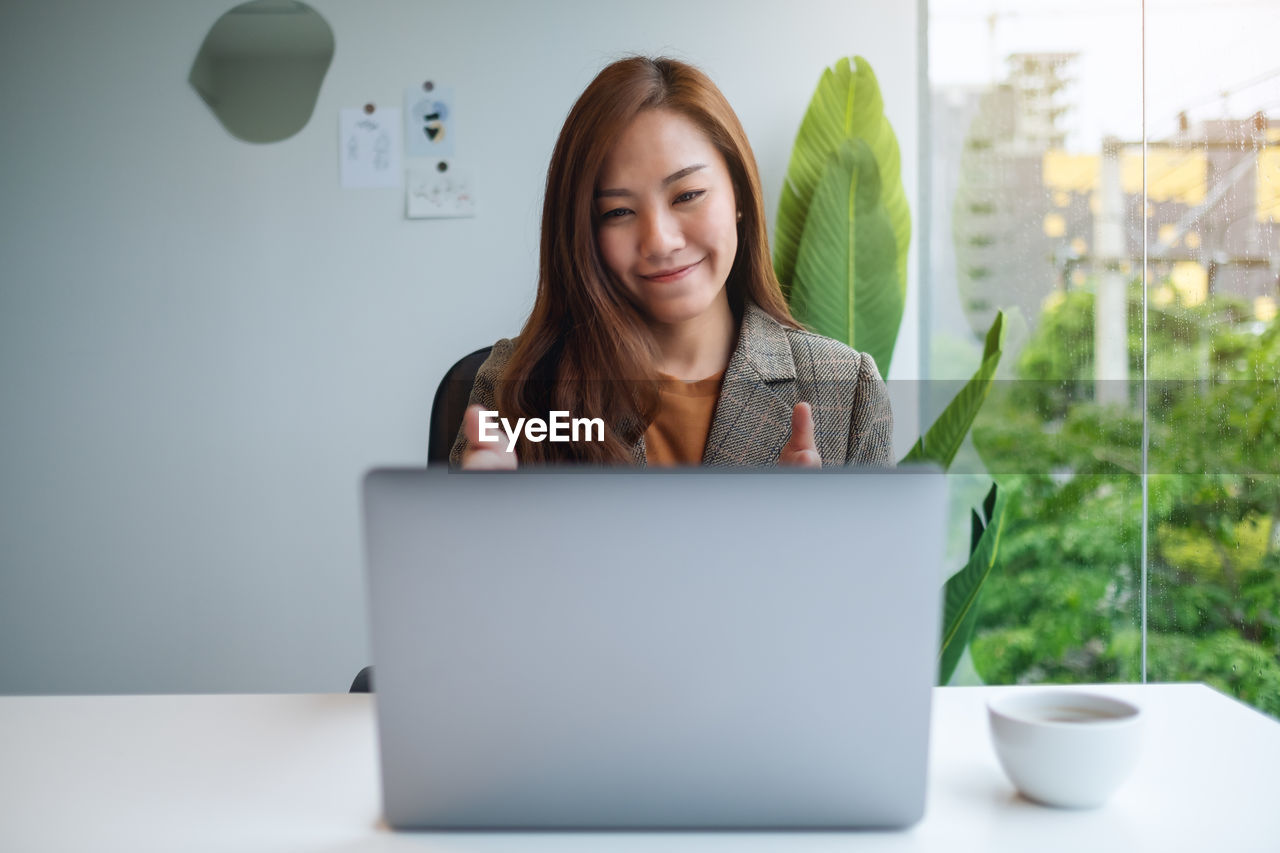 portrait of young woman using laptop on table