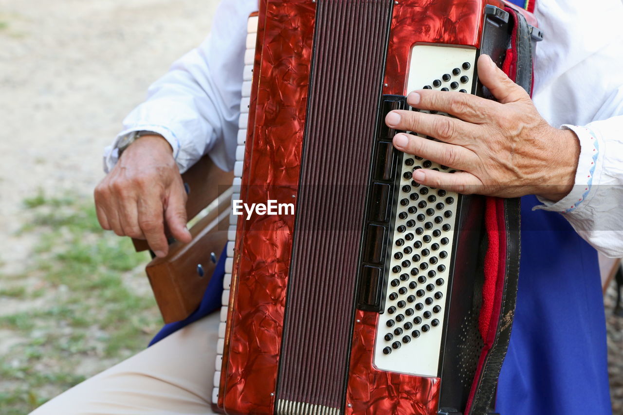 Midsection of man playing accordion