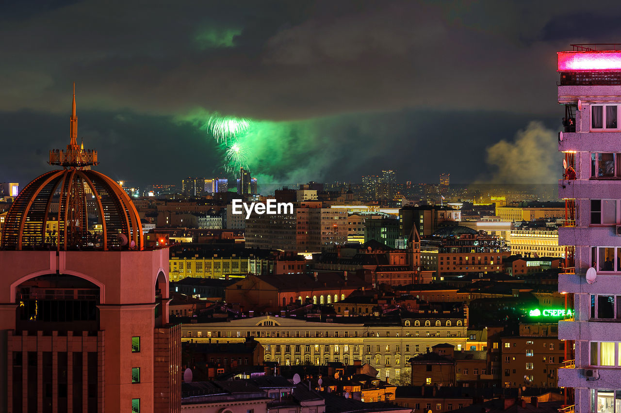 ILLUMINATED CITY BUILDINGS AGAINST SKY AT NIGHT