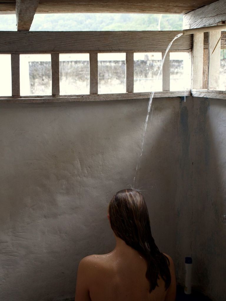 Rear view of woman taking shower