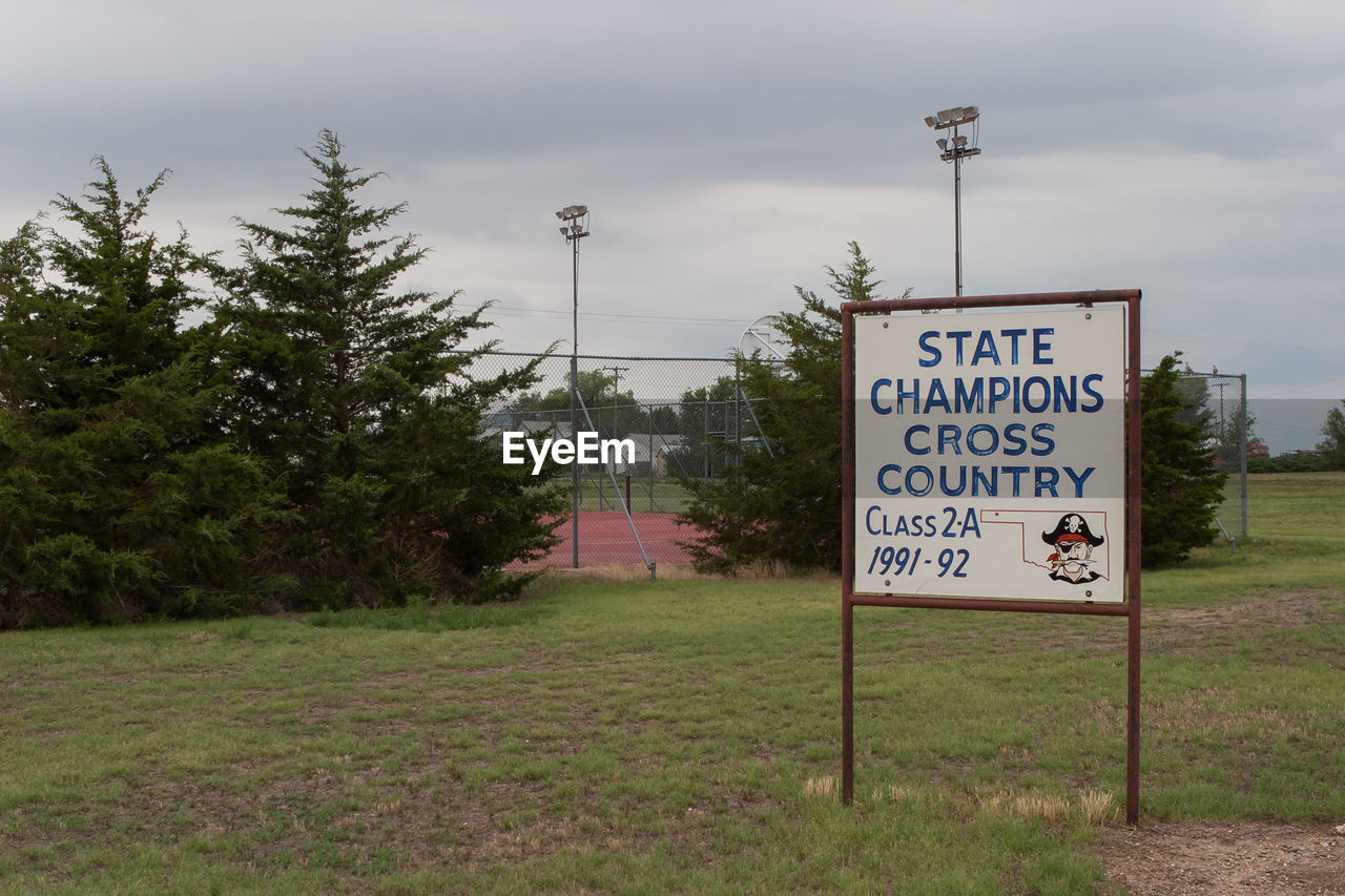 SIGNBOARD ON GRASSY FIELD