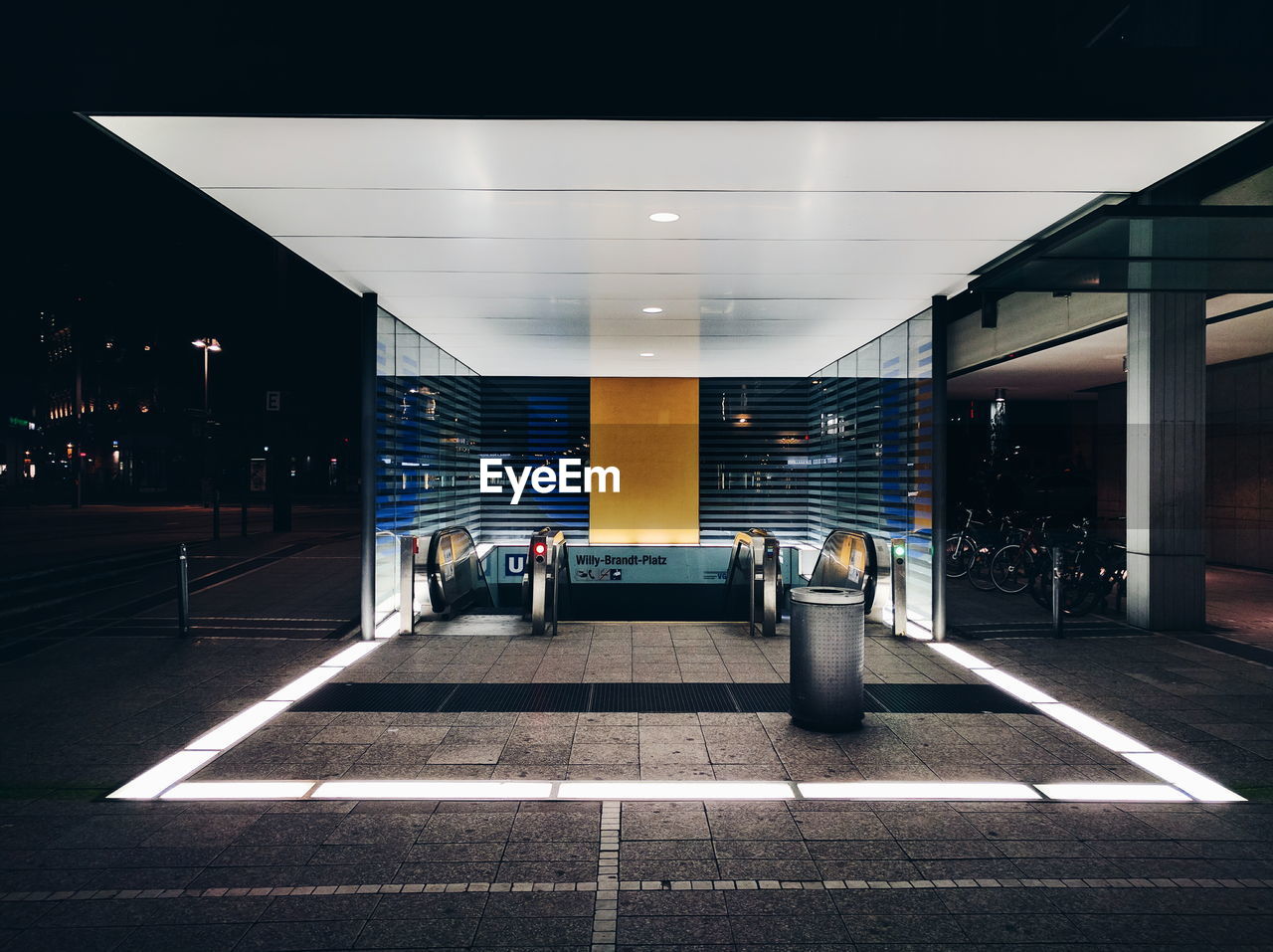 Illuminated escalator at sidewalk in city