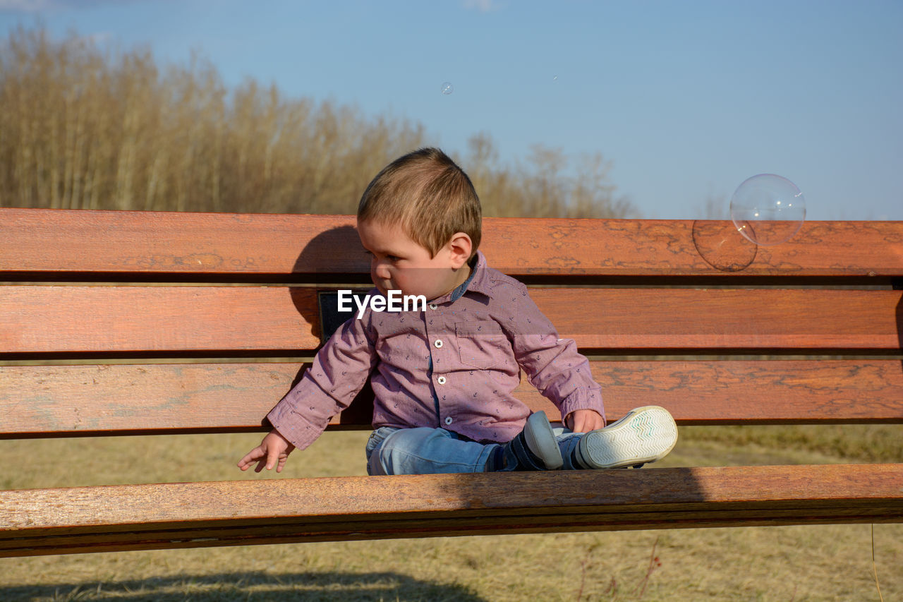 Baby sitting on a bench at the park