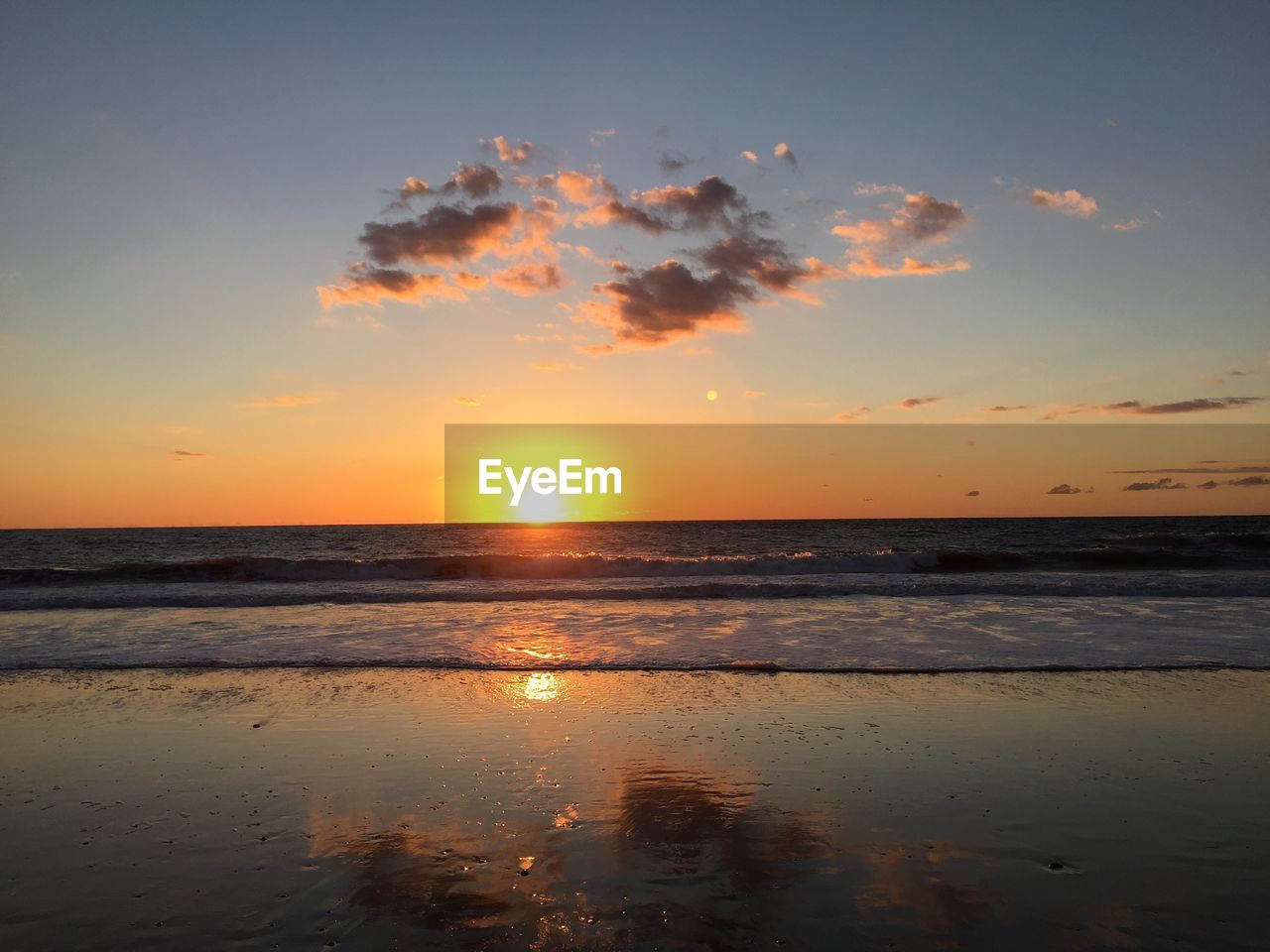 Scenic view of beach against cloudy sky