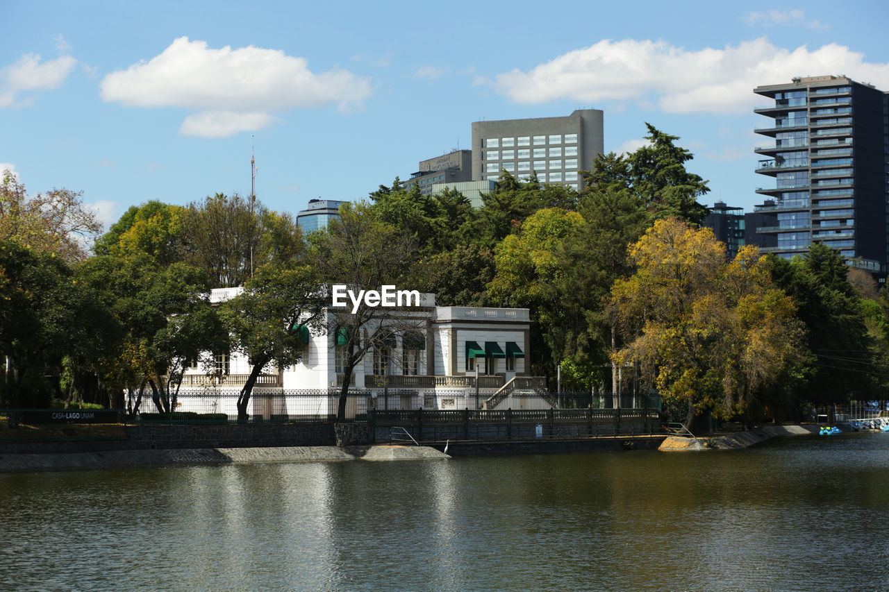 BUILDING BY RIVER AGAINST SKY