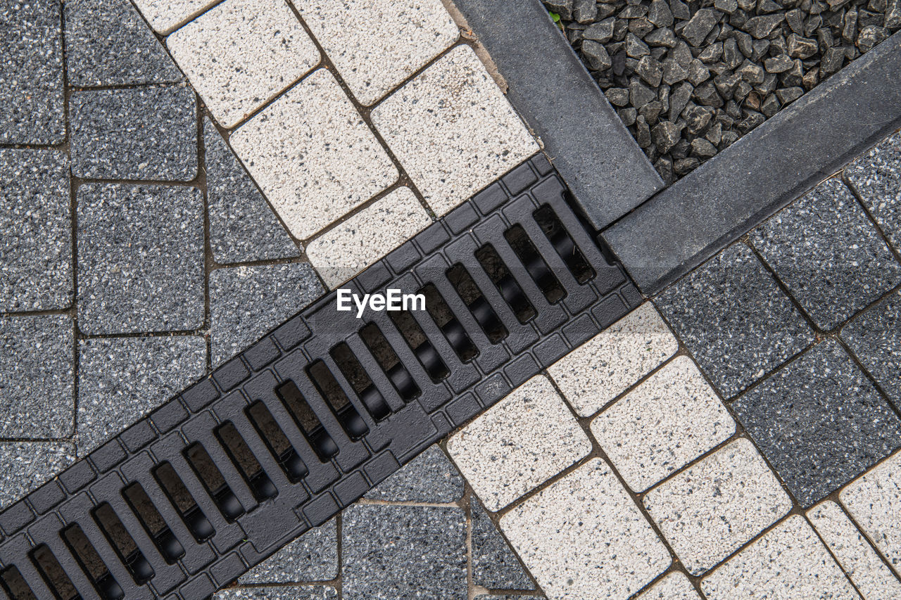 HIGH ANGLE VIEW OF COBBLESTONE STREET IN CITY