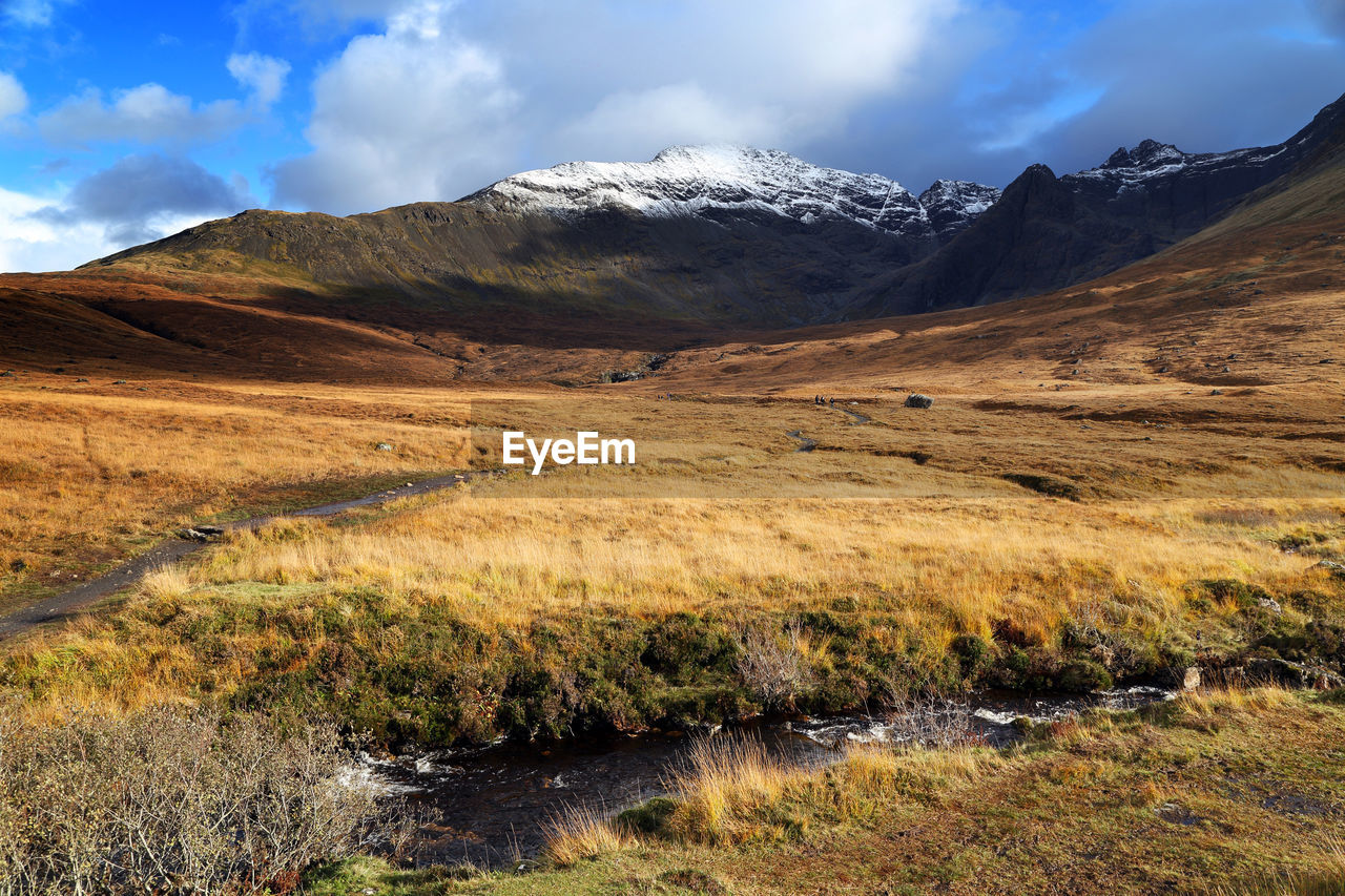 Scenic view of mountains against cloudy sky