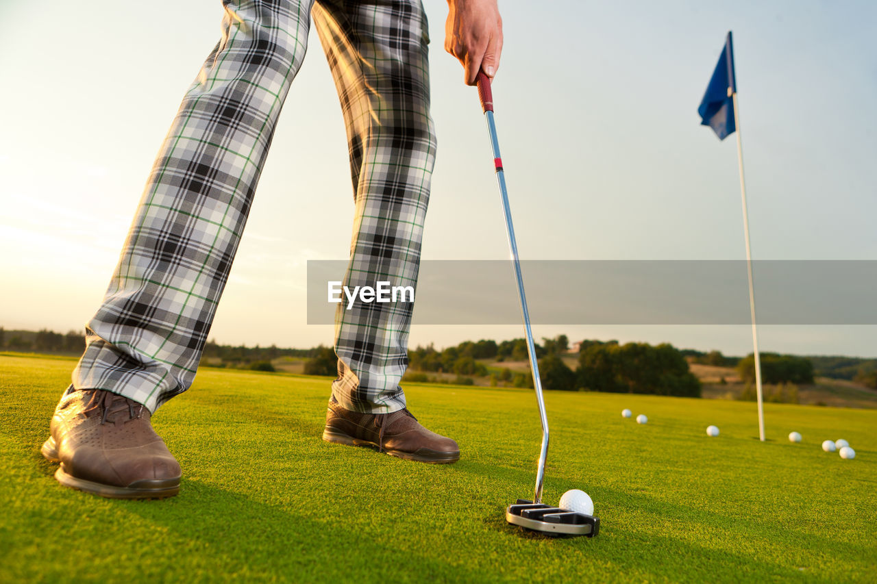 Low section of man standing on golf course