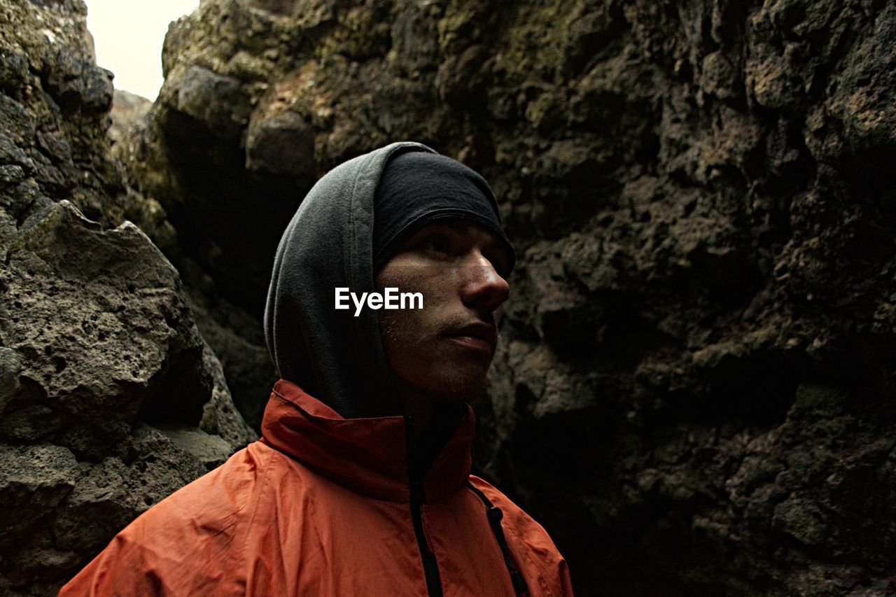 Close-up of thoughtful man wearing warm clothing against rocks