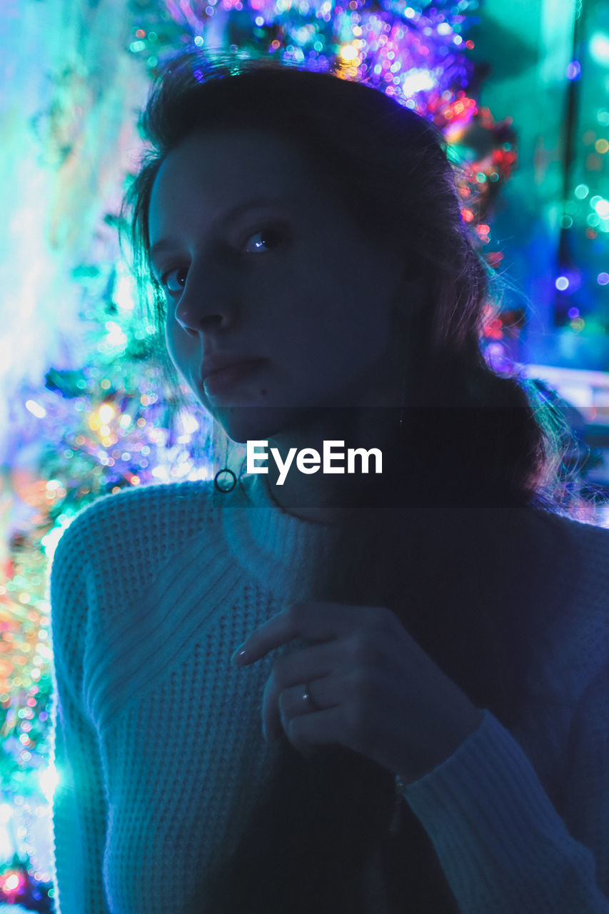 Portrait photo of a girl on a background of colorful garlands