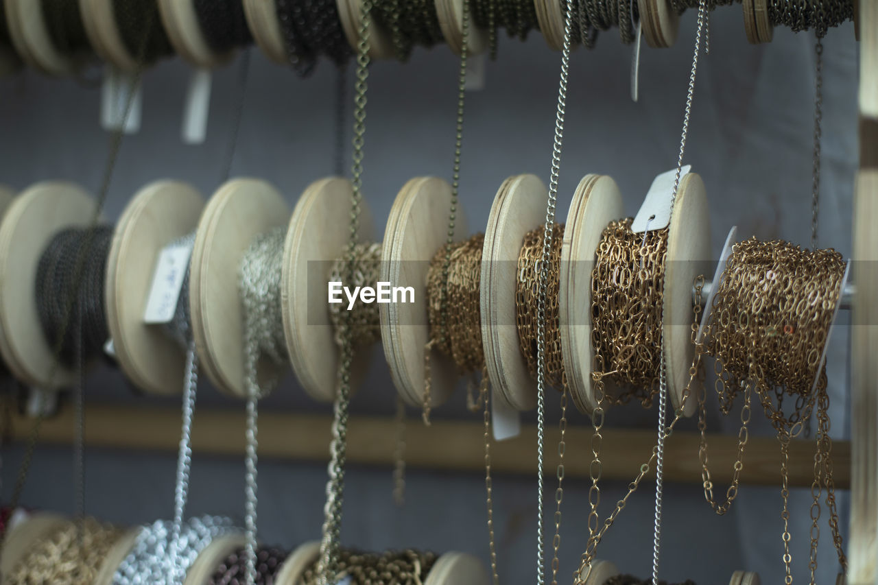 Chain decoration on coils. sale of jewelry. chains wound on reels. different threads for creativity.