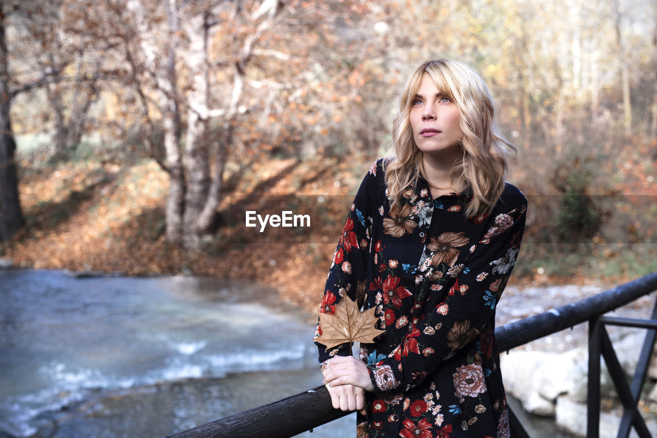 Woman near the river with autumn landscape