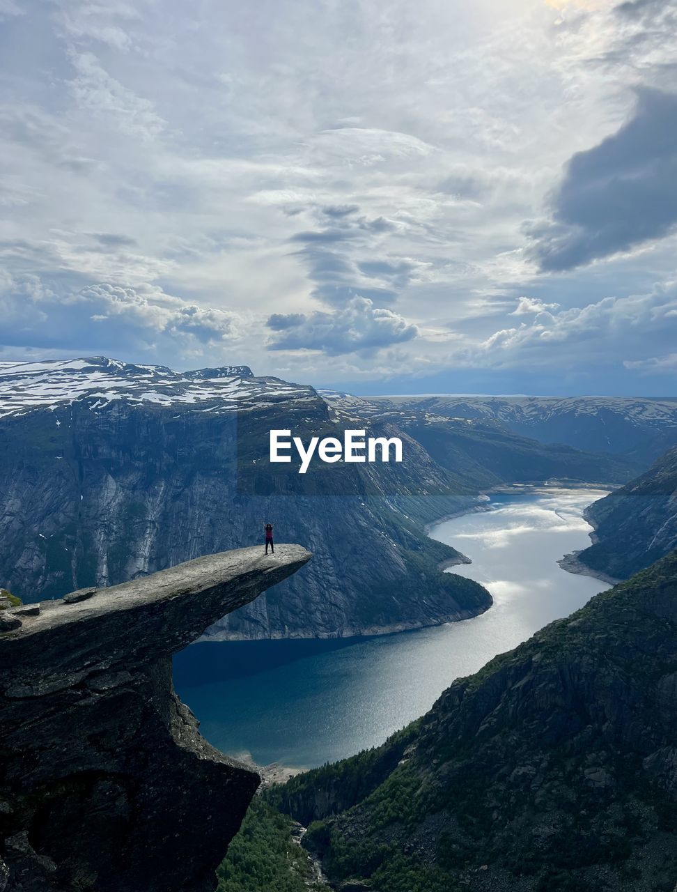 View of trolltunga and the lake below it. i am visibleon top of the trolltunga rock.