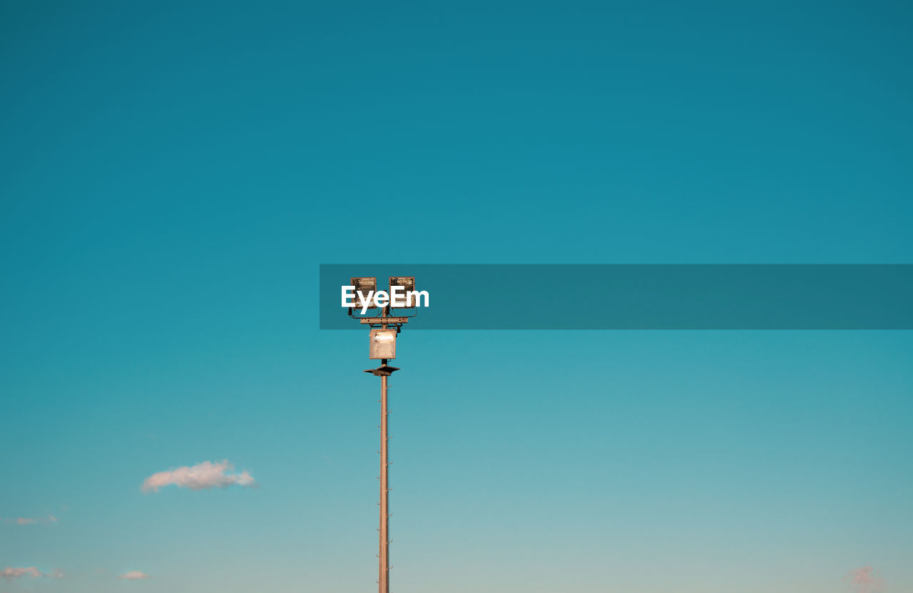 Low angle view of street light against blue sky