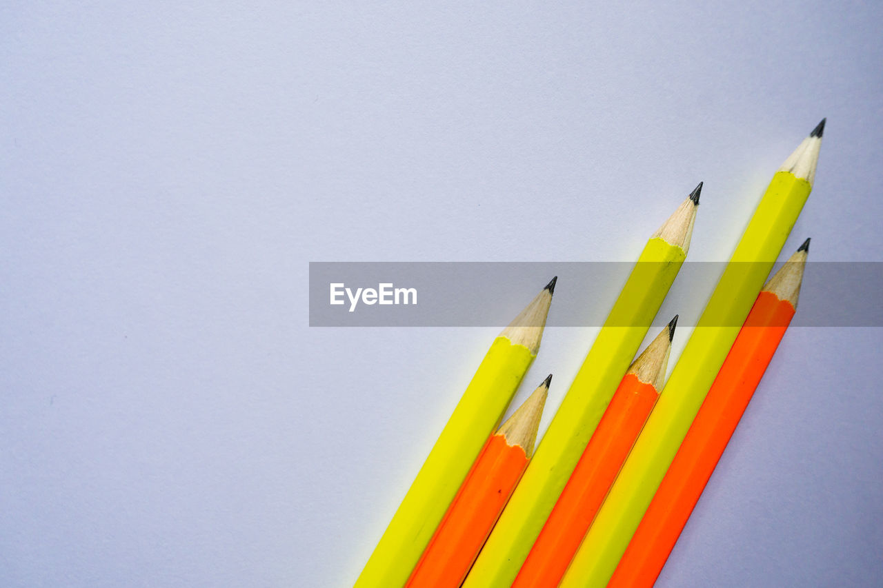 CLOSE-UP OF MULTI COLORED PENCILS AGAINST WHITE BACKGROUND