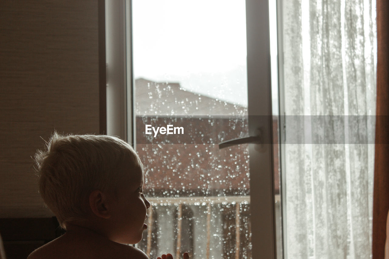 Portrait of a boy looking to the side on a rainy day