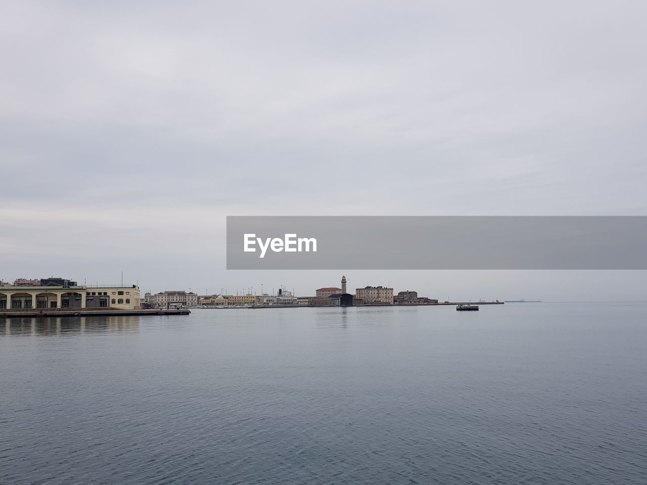 Scenic view of sea by buildings against sky